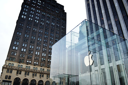glass Apple company building beside high rise building under white sky thumbnail