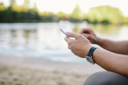 Young Man Using His Phone on beach thumbnail