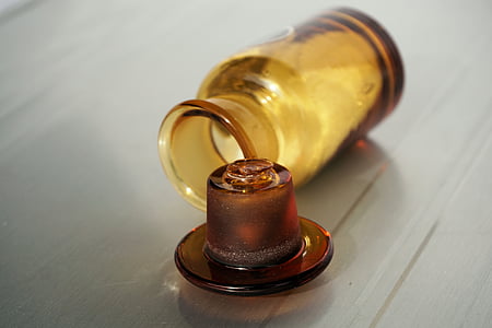 amber glass bottle open on brown wooden surface thumbnail