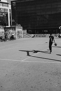 grayscale photo of man holding basketball doing tricks thumbnail