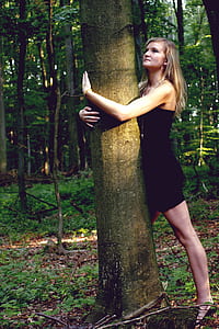 woman hugging brown tree trunk thumbnail