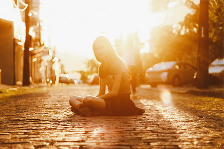 sepia photography of woman sitting down on street thumbnail