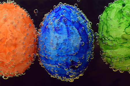 three orange, blue, and green decorative balls with water bubbles vector art thumbnail