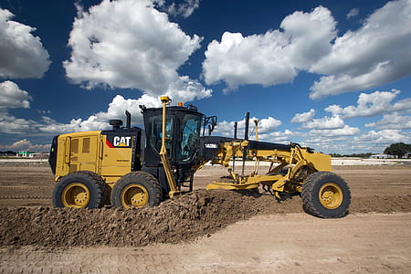 yellow CAT grader on plane dirt field during daytime thumbnail