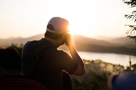 man taking a photo of lake and mountain thumbnail