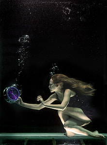 photo of woman underwater holding silver and purple alarm clock thumbnail