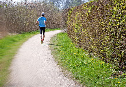 man running on road near plants at daytime thumbnail
