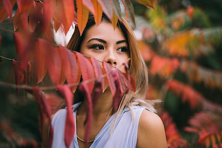 woman standing beside orange leafed plant selective focus photography thumbnail