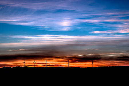 silhouette of five turbines during golden hour thumbnail