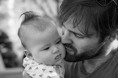 grayscale photography of man kissing baby thumbnail