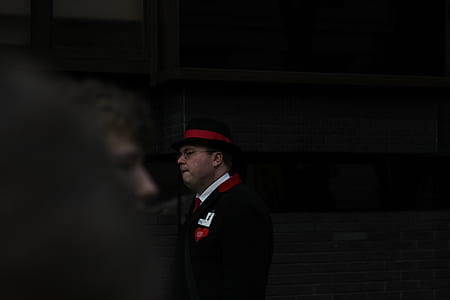 man in black and red suit jacket and fedora thumbnail