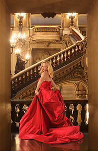 woman in red strapless gown walking near stairs thumbnail