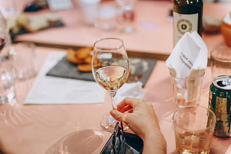 Person Holding Wine Glass Near Clear Shot Glasses thumbnail