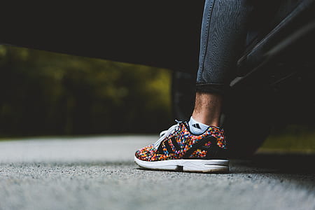 person wearing unpaired black and multicolored adidas running shoe thumbnail