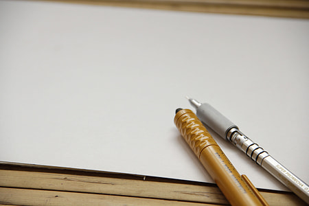 gold-colored and silver-colored pens on white surface thumbnail