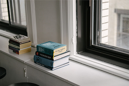 pile of books on white rack thumbnail