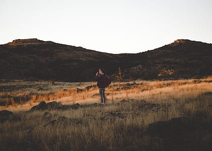 man standing on brown grass field during daytime thumbnail