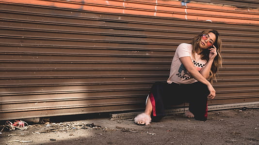woman sitting and leaning beside brown roller shutter thumbnail