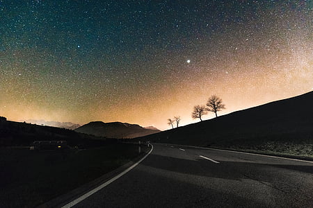 photo of black asphalt road under sky full of stars thumbnail