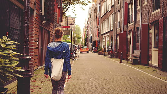 blonde haired woman in blue pullover hoodie standing beside brown pole thumbnail