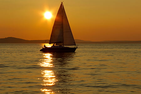 brown and white boat on body of water during sunset thumbnail