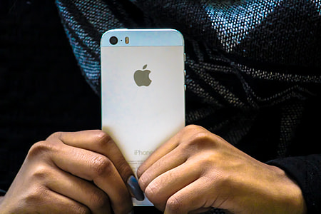 Closeup shot of a person holding their mobile iPhone smartphone in hand thumbnail