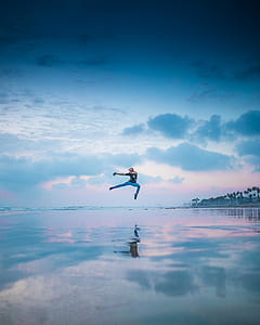 man jumping above water during daytime thumbnail