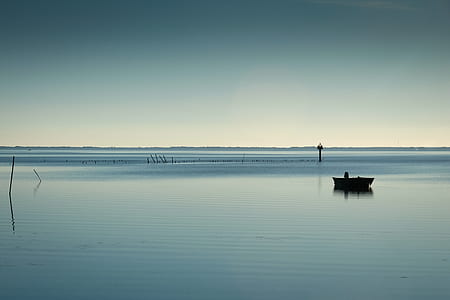 boat on calm body of water during daytime thumbnail