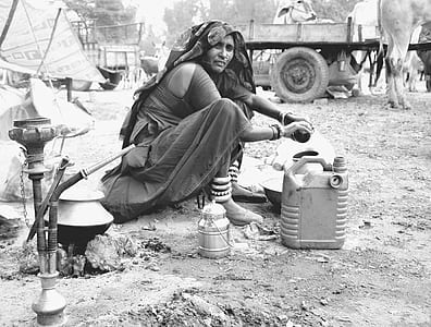 grayscale photo of woman sitting beside gallon thumbnail