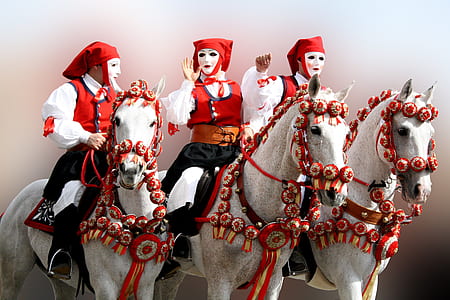 three people wearing white-and-red costumes riding white horses thumbnail