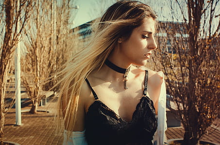 Woman Wearing Black Choker and Sleeveless Top Walking on Street thumbnail