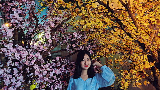 woman wearing blue tops standing beside trees painting thumbnail