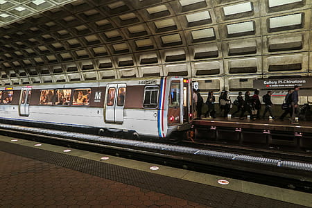 Trains arriving and leaving in DC metro station with riders on platform. thumbnail