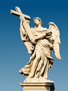 angel holding cross statue during clear blue sky thumbnail