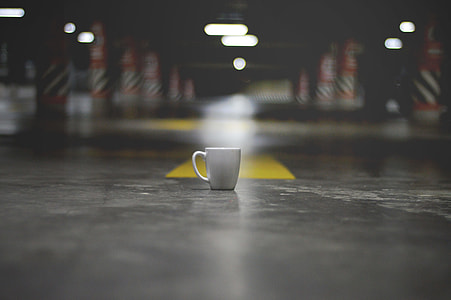 white ceramic mug on parking lot ground thumbnail