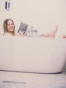 woman reading book while in bathtub thumbnail