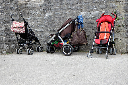 three empty strollers beside wall thumbnail