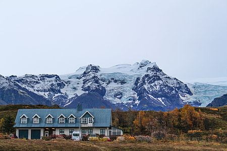 white and teal house near mountain under white sky thumbnail