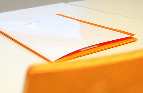 white and orange printed papers on white surface thumbnail