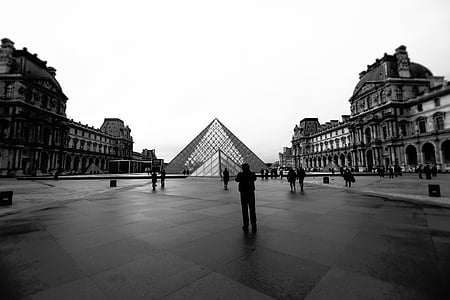 grayscale photography of people near pyramid building thumbnail