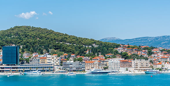 white-and-red houses between body of water and sky thumbnail