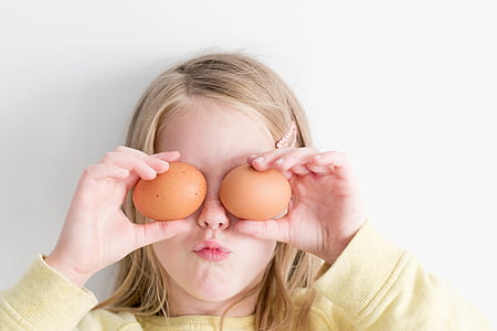 girl holding two eggs covering her eyes thumbnail