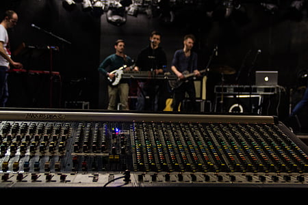 three men standing while playing instruments thumbnail