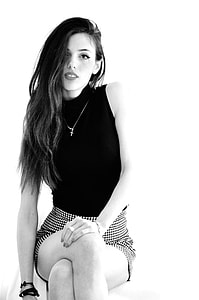 sitting and smiling woman wearing sleeveless top and miniskirt thumbnail
