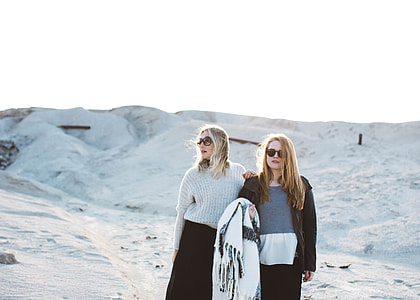 two women standing on snowfield during daytime thumbnail