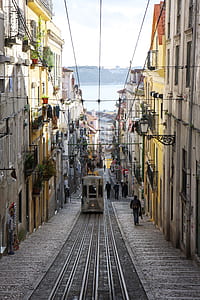 people walking on street near buildings and tram at daytime thumbnail