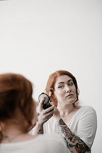 woman holding compact palette and makeup brush thumbnail