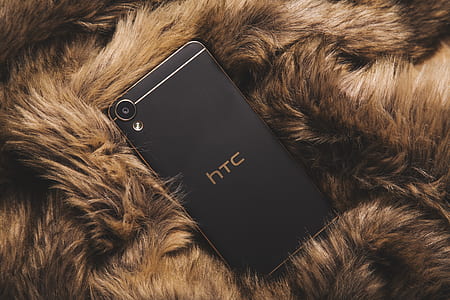 black HTC Desire 820 smartphone on brown furry blanket thumbnail