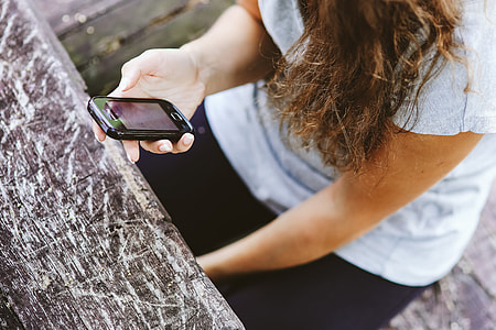 Young woman holding the white mobile phone thumbnail
