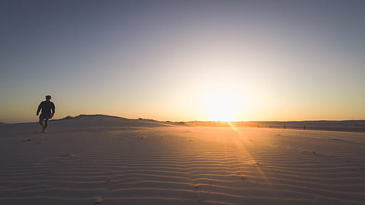 Person Standing on Desert during Sunset thumbnail